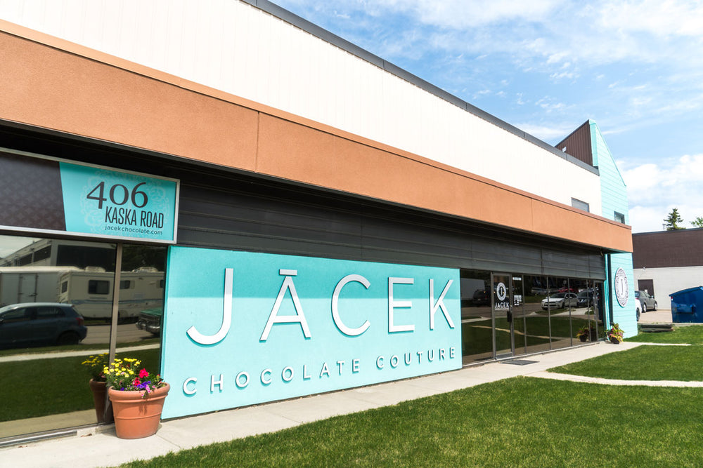 The exterior of the JACEK Studio. A large teal wall is featured, which reads "JACEK Chocolate Couture" in large letters.
